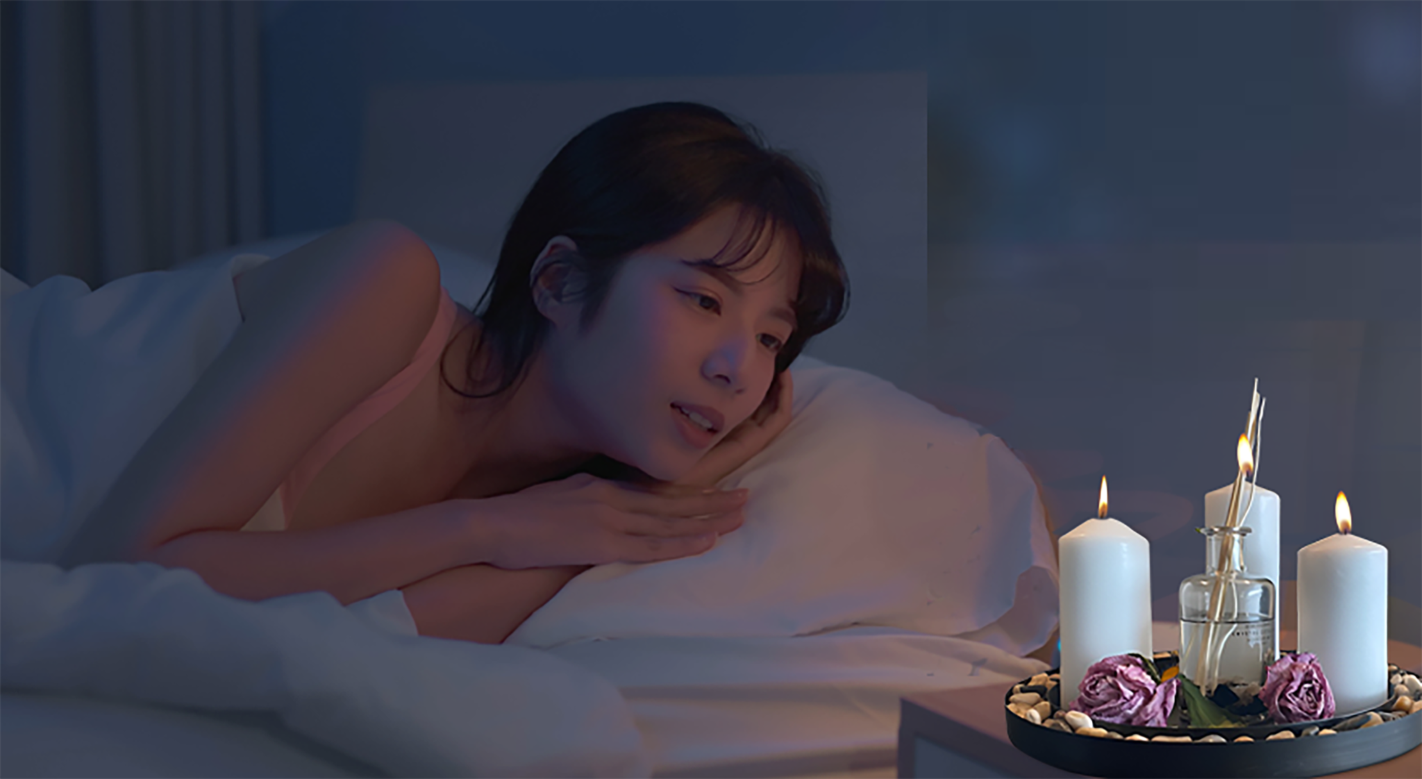 A woman in bed watching candles in candle plates